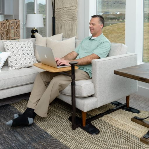 Man sitting using a laptop tray table