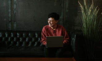 Girl sitting on a sofa with computer on her lap